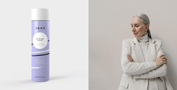 Shampoo antigiallo professionale JAAS No Yellow accanto a una donna con capelli grigi luminosi, ideale per neutralizzare i riflessi gialli e mantenere il tono freddo dei capelli biondi, bianchi o argentati